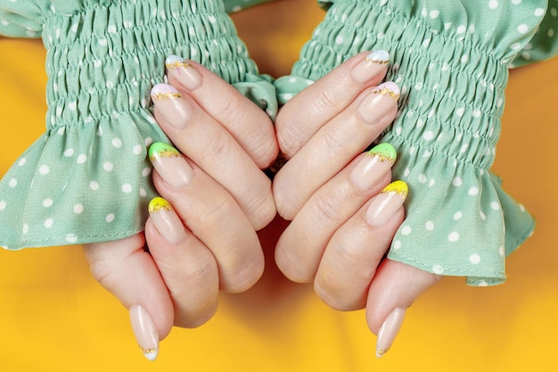 Manucure française en vert jaune violet sur fond uni Nail art sur les ongles des femmes Women's