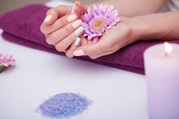 Manucure. Gros plan de belle femme mains avec des ongles naturels dans un salon de beauté.