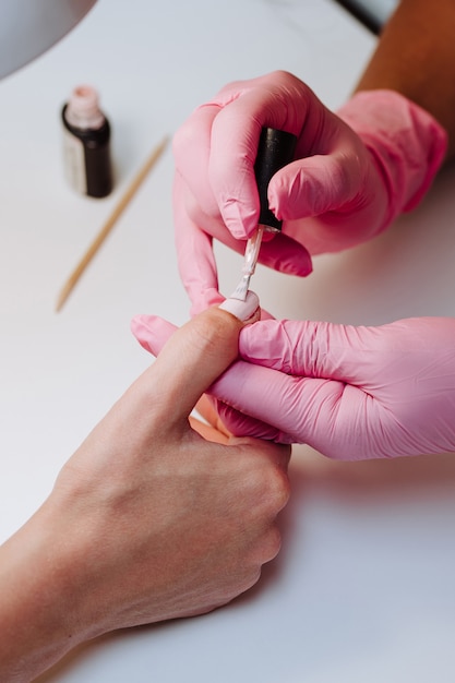 Manucure peint les ongles d'une fille