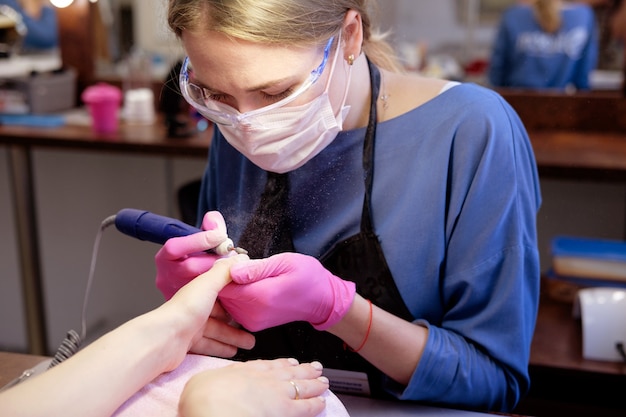 Manucure polissage des ongles à l'aide d'une machine à polir