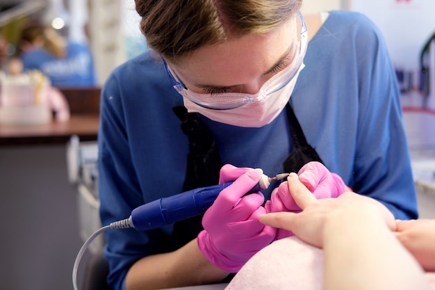 Manucure polissage des ongles à l'aide d'une machine à polir