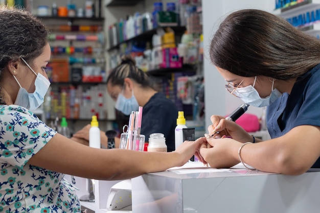 Manucure professionnelle lime les ongles d'une femme avec une lime à ongles dans un salon de beauté professionnel