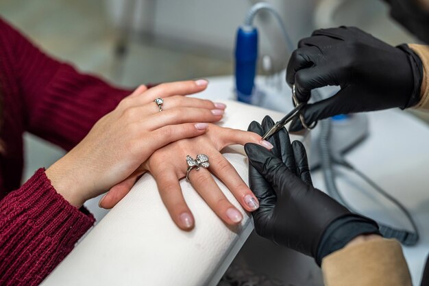 Manucure rend les procédures préparatoires du client pour l'application de vernis dans un salon de beauté