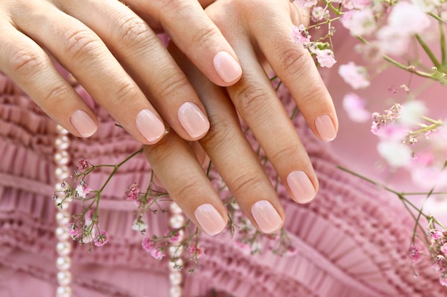 Manucure rose tendre sur ongles courts avec gypsophile.