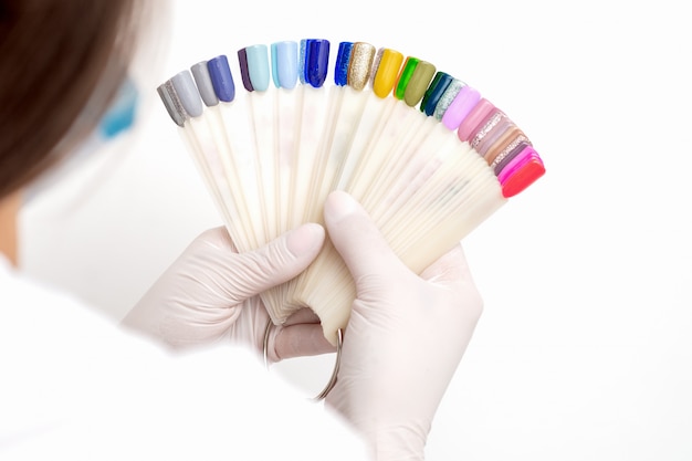 Manucure tenant des échantillons de couleur des ongles