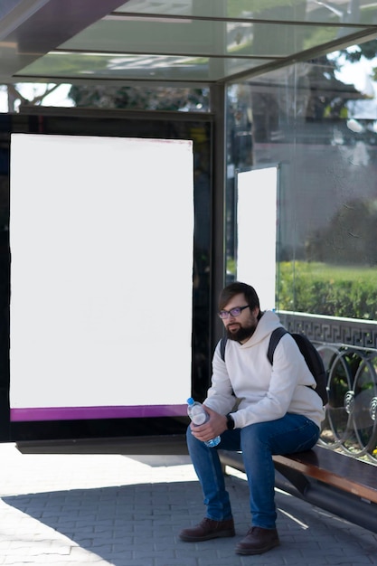 Photo maquette d'arrêt de bus de la ville moderne espace vide pour la publicité homme attendant un bus