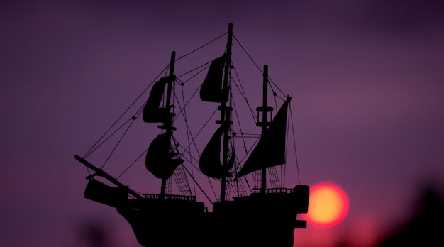 Photo maquette de bateau avec le coucher de soleil en arrière-plan