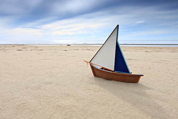 Maquette de bateau sur la plage ensoleillée d'été