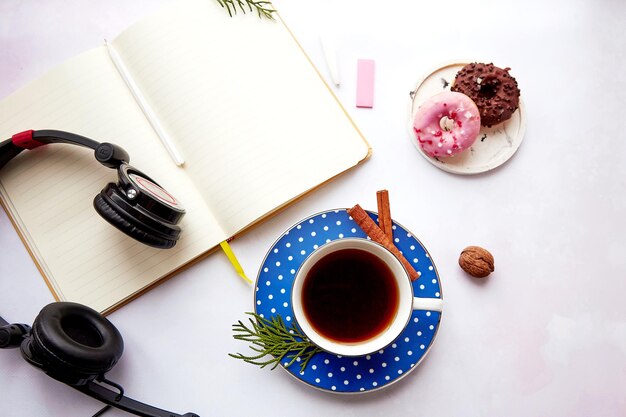 Maquette bloc-notes avec casque tasse à café et bâtons de cannelle avec des beignets. Prendre un webinaire.