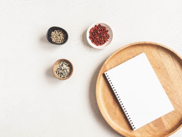 Maquette de bloc-notes de cuisine pour le texte culinaire sur un plateau en bois et des épices