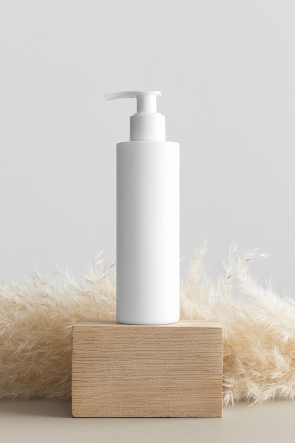 Maquette de bouteille de distributeur de shampoing cosmétique blanc avec une décoration de pampa