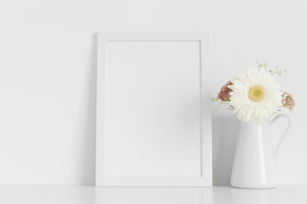 Maquette de cadre blanc avec un bouquet de fleurs sur le tableau blanc