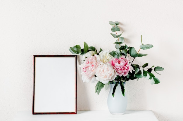 Maquette de cadre avec un bouquet de pivoines dans un vase.