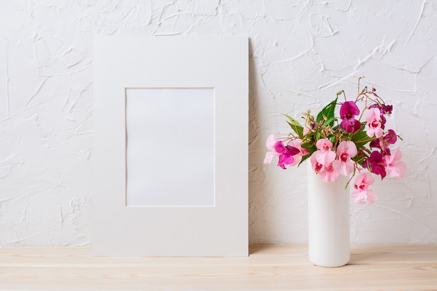 Maquette de cadre mat blanc avec bouquet de fleurs rose et violet