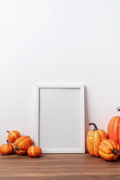 Maquette de cadre photo d'art avec des écharpes et des feuilles d'automne fond blanc