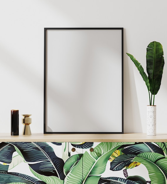Photo maquette de cadre photo dans un intérieur moderne d'ambiance tropicale avec mur blanc, debout sur une commode avec impression de feuilles de palmier, rendu 3d