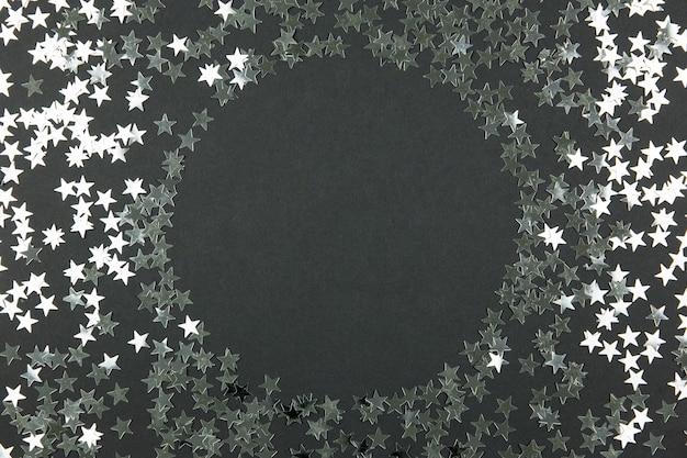 Maquette de cadre rond avec décoration de confettis scintillants scintillants vacances festives sur fond sombre