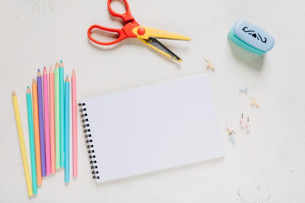 maquette de carnet de croquis, feuille de papier blanche et crayons de couleur, fournitures scolaires