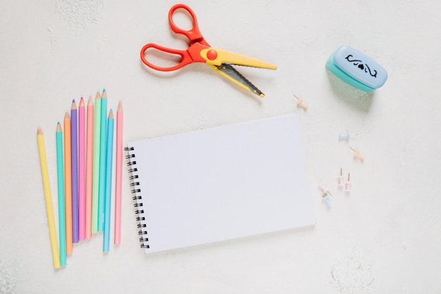 maquette de carnet de croquis, feuille de papier blanche et crayons de couleur, fournitures scolaires