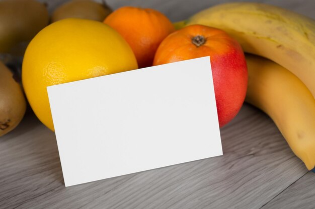 Maquette de carte et de livre blanc harmonisée avec des fruits frais pour créer une symphonie visuelle