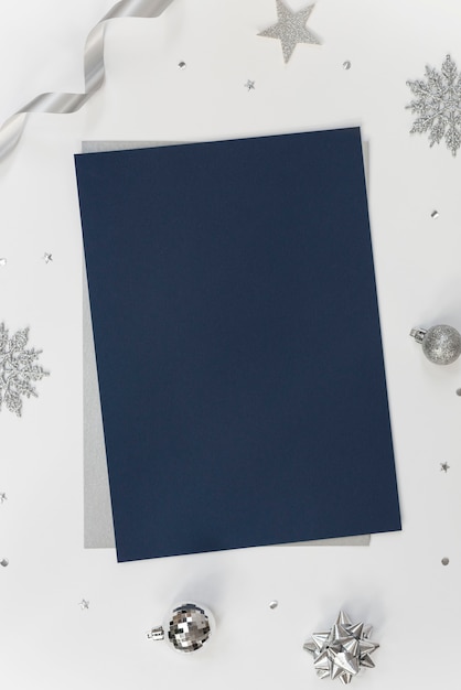 Maquette de carte de papier de voeux sur blanc avec des décorations de Noël et des confettis.