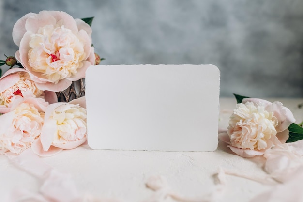 Maquette de carte postale sur fond de fleurs de pivoines sur fond clair