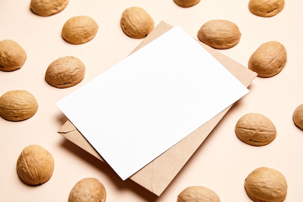 Maquette de carte vierge avec coquilles de noix et enveloppe sur fond beige Maquette de carte de vacances blanche