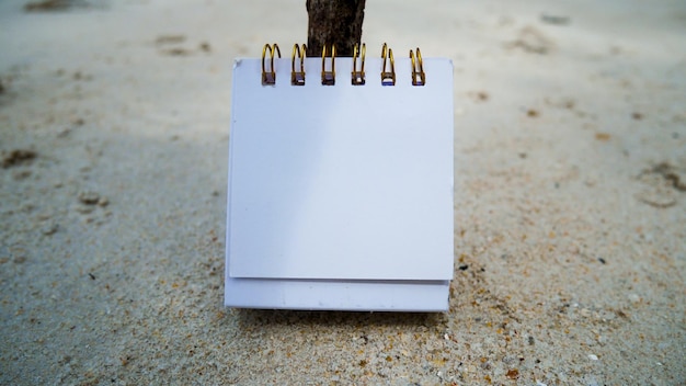 Maquette de carte de visite en papier sur fond de sable de plage