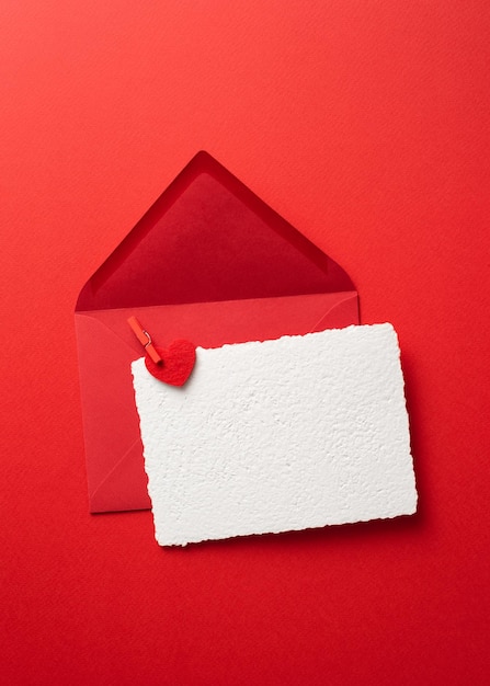Maquette de carte de voeux Saint Valentin dans une enveloppe sur fond rouge avec des coeurs