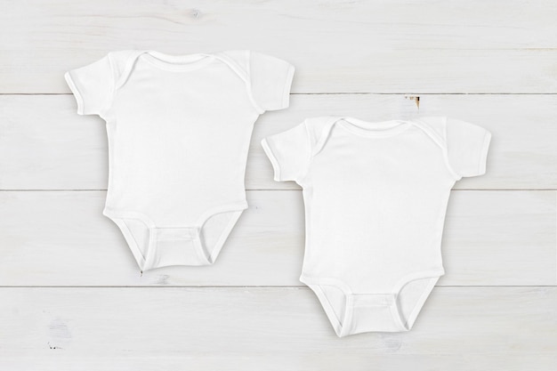 Photo maquette de deux bébés blancs sur fond de bois blanc contemporain