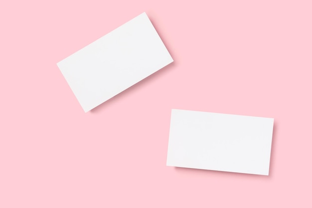Maquette de deux cartes de visite en coupe sur un fond de minimalisme rose Modèle de conception