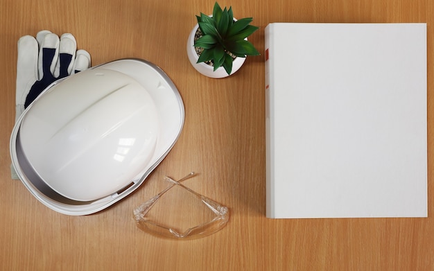 Maquette sur dossier blanc sur table avec casque de chantier et lunettes de protection