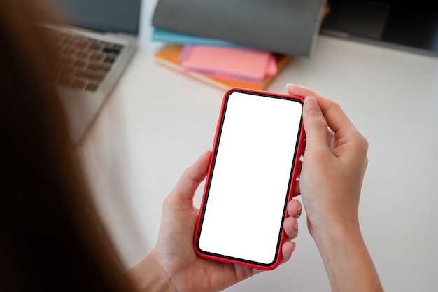 Maquette du téléphone dans la main de la femme montrant avec un écran vide