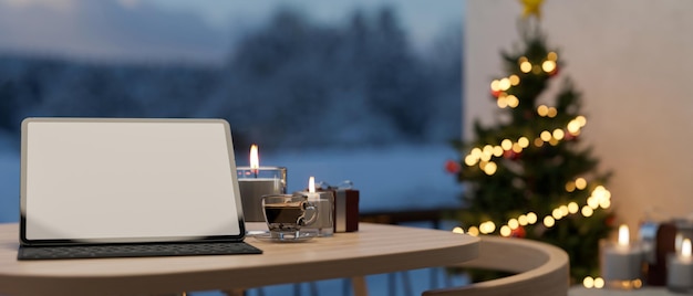 Maquette d'écran blanc de tablette sur la table sur fond flou avec arbre de Noël