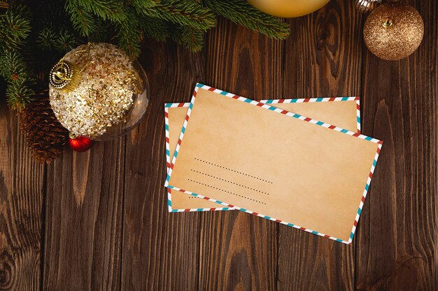 Maquette d'enveloppe d'artisanat de Noël. Lettre vide minimale blanche sur table en bois avec des décorations festives.