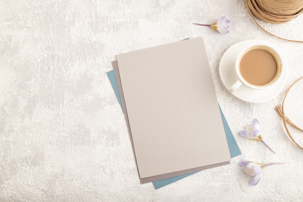 maquette de feuille de papier gris avec des fleurs de crocus de perce-neige de printemps et une tasse de café