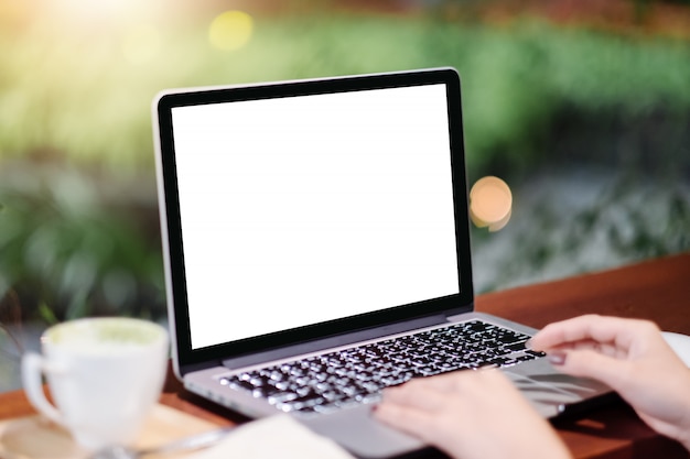 Maquette image de femme d&#39;affaires en utilisant et en tapant sur un ordinateur portable avec écran blanc vierge