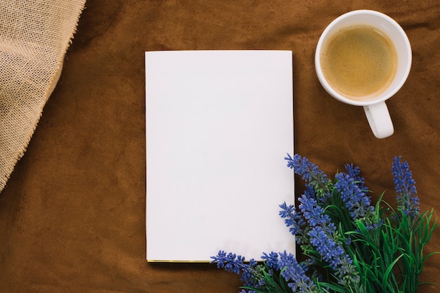 Photo maquette de livre avec tasse à café et fleurs