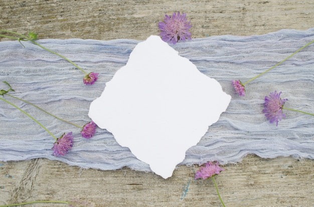 Photo maquette de mariage avec des fleurs roses sur un coureur violet et fond de bois rustique olr