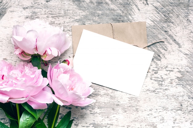 Photo maquette de marque élégante pour afficher vos œuvres d'art. carte de voeux vierge ou invitation de mariage avec des fleurs de pivoine rose