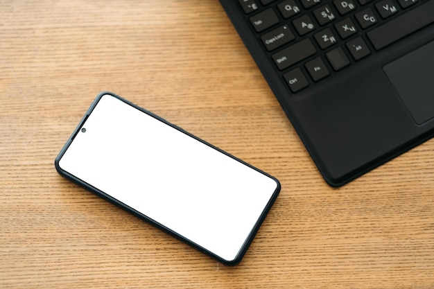 Maquette mobile travail de bureau technologie numérique smartphone avec écran blanc sur un bureau en bois ouvert