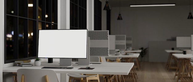 Une maquette d'ordinateur sur un tableau blanc dans un bureau moderne avec des rangées d'ordinateurs la nuit