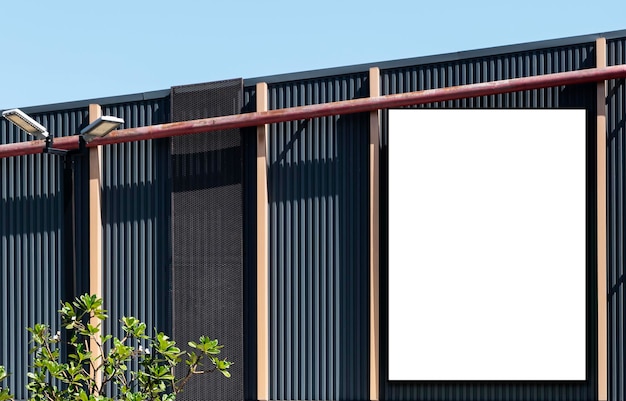 Maquette de panneau d'affichage de fond blanc et chemin de détourage sur le bâtiment avec fond de ciel bleu