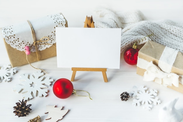 Maquette de personnalisation élégante pour afficher vos œuvres d'art. De jolis cadeaux de Noël vintage pour le nouvel an se moquent sur un fond en bois.
