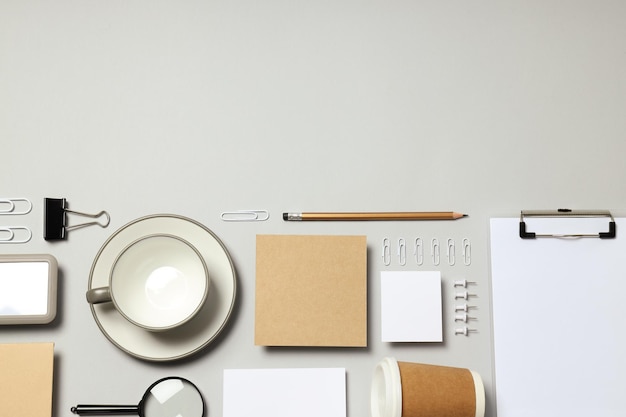 Maquette à plat avec différents accessoires de bureau sur fond gris clair