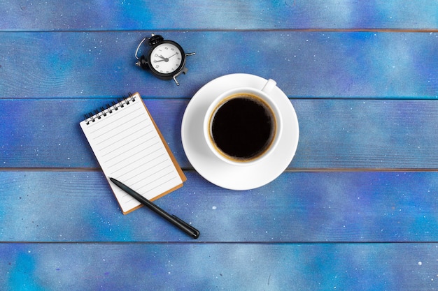 Maquette pour la liste de contrôle, papier vide avec tasse à café sur bois bleu. Concept de bureau, d'écrivain ou d'étude