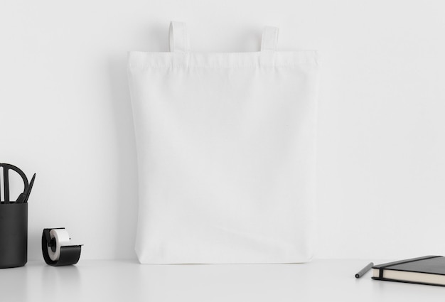 Maquette de sac fourre-tout blanc avec accessoires d'espace de travail sur un tableau blanc
