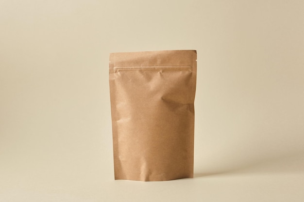 Maquette de sac en papier vierge sur fond beige Emballage écologique, recyclage du papier, zéro déchet, concept de produits naturels. Copiez l'espace.