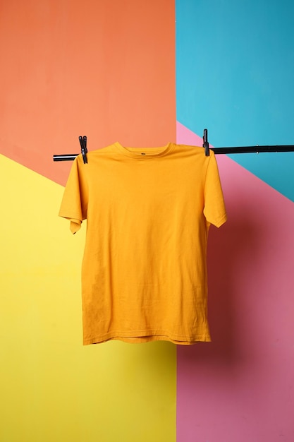 Maquette de t-shirt jaune moutarde suspendue sur fond coloré