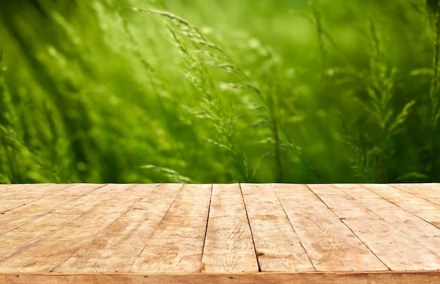 Maquette. Table de terrasse en bois vide avec fond de bokeh de feuillage.